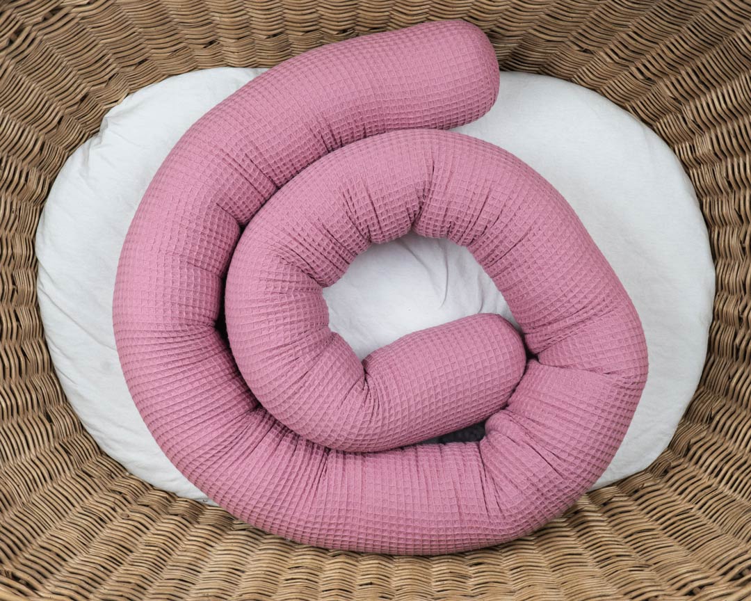 Bettschlange aus Waffelpiqué in altrosa als Umrandung im Babybett, schützt sie den Kopf vor Gitterstäben und Zugluft und verhindert, dass der Schnuller aus dem Bett fällt.
