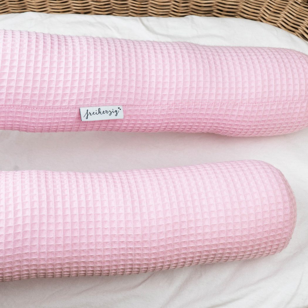 Bettschlange aus Waffelpiqué in rosa als Umrandung im Babybett, schützt sie den Kopf vor Gitterstäben und Zugluft und verhindert, dass der Schnuller aus dem Bett fällt.