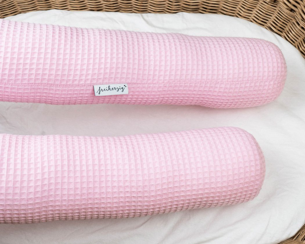 Bettschlange aus Waffelpiqué in rosa als Umrandung im Babybett, schützt sie den Kopf vor Gitterstäben und Zugluft und verhindert, dass der Schnuller aus dem Bett fällt.