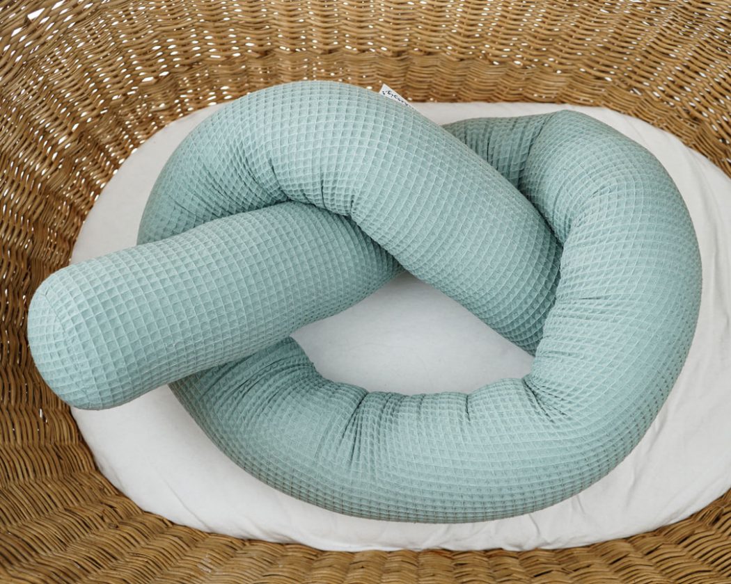 Bettschlange aus Waffelpiqué in grün als Umrandung im Babybett, schützt sie den Kopf vor Gitterstäben und Zugluft und verhindert, dass der Schnuller aus dem Bett fällt.